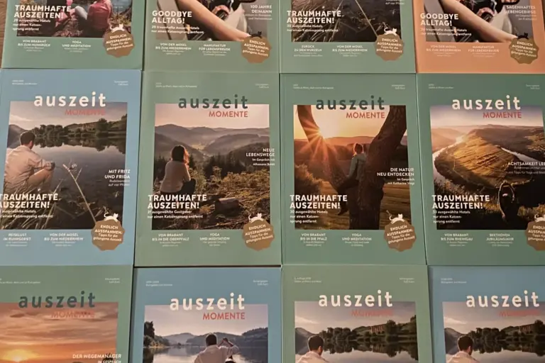 Das Magazin Auszeit-Momente vor Ort auf Messen. Das Bild zeigt mehrere Ausgaben des Magazins