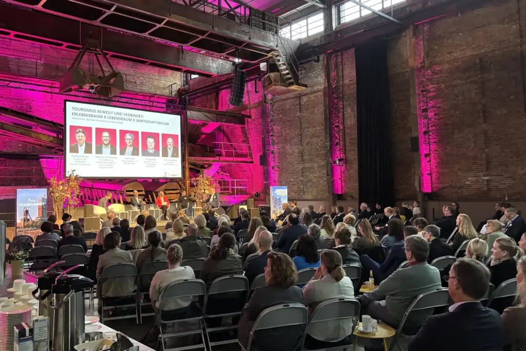 Tourismustag NRW 2026 in der Kokerei Hansa in Dortmund, Diskussion auf der Bühne und Zuschauer